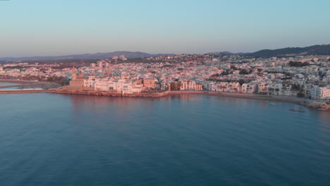 Aerial-golden-hour-drone-shot-over-Mediterranean-coastal-town-Sitges