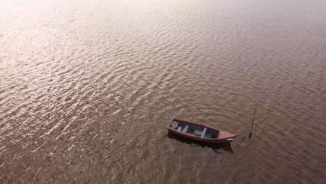 4k aerial view of a wooden boat anchored in ria de aveiro on the estuary of river vouga