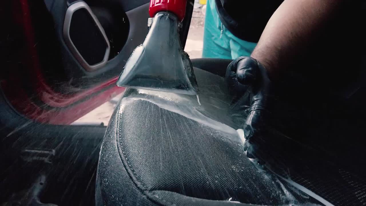 hombre aplicando desinfectante líquido al asiento del pasajero