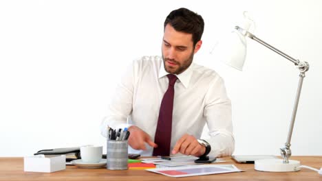 hombre de negocios trabajando en su escritorio y hablando por teléfono móvil
