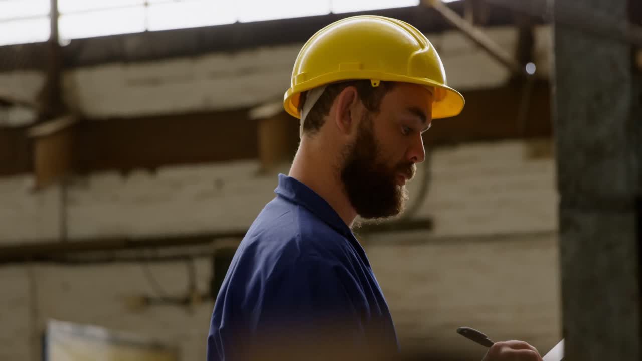 metalúrgico escribiendo en el clipboard en el taller 4k