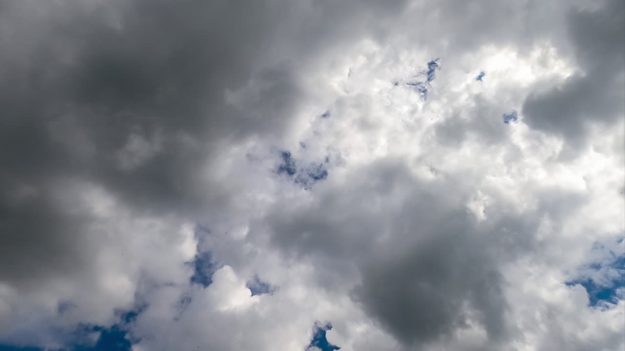 Dramatic cloudscape building in the atmosphere. Thick grey clouds forming heavy rain clouds. Low angle timelapse.