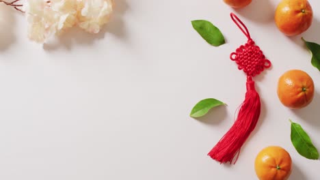 video of red chinese decorations and oranges on white background