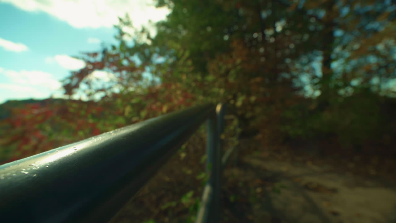 muñeco lento por un pasamanos en un sendero forestal con el pasamanos enfocado