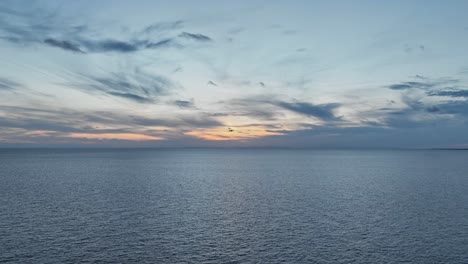 mavic drone seen flying into sunset along the european coastline at last light