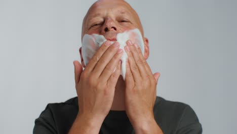 man applying facial cleanser