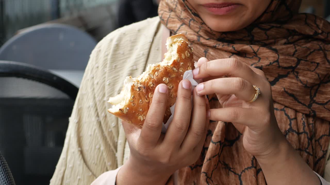 Una mujer comiendo un sándwich.