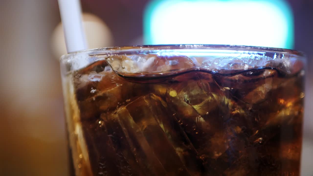 el hormigueo de coca-cola en un vaso frío sobre la mesa en el restaurante