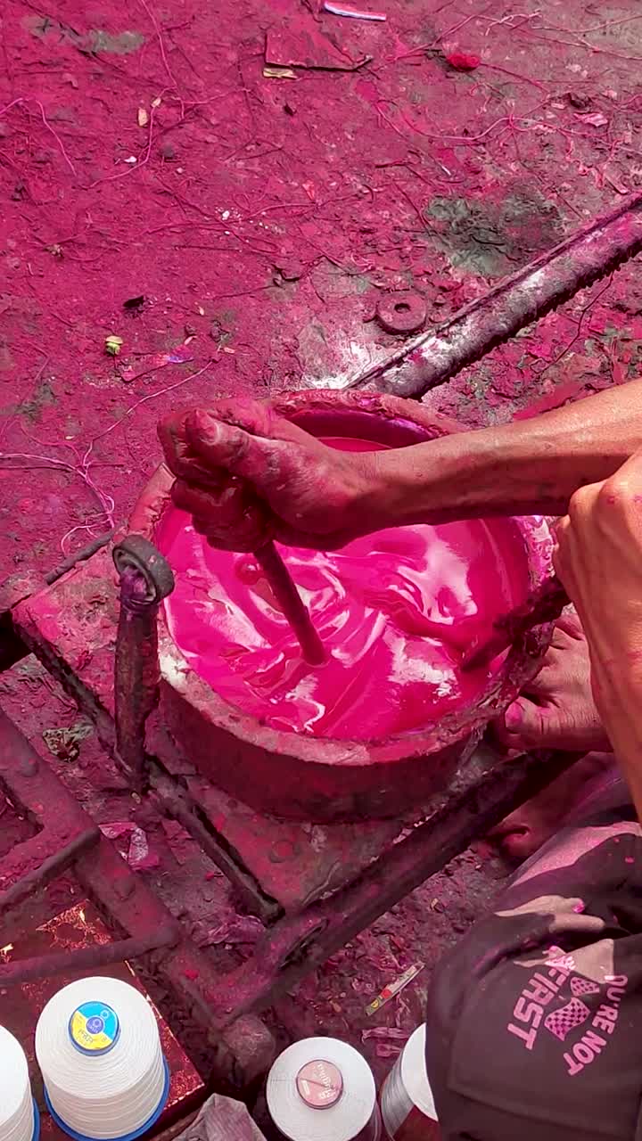 Persiapan pewarna tali layang-layang di India yang menunjukkan pencampuran manual warna merah muda cerah untuk tampilan vertikal benang manja, proses tradisional yang digunakan sebelum festival Makar Sankranti dan Uttarayan