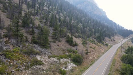 Aerial-footage-of-Highway-99-leading-past-pavilion-lake-on-a-smoky-summer-day