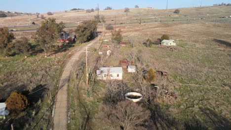 drone real-time footage over clarksville, california, usa, along the main road showing traditional houses, trees and rural farmland, moving forward towards the highway and passing traffic