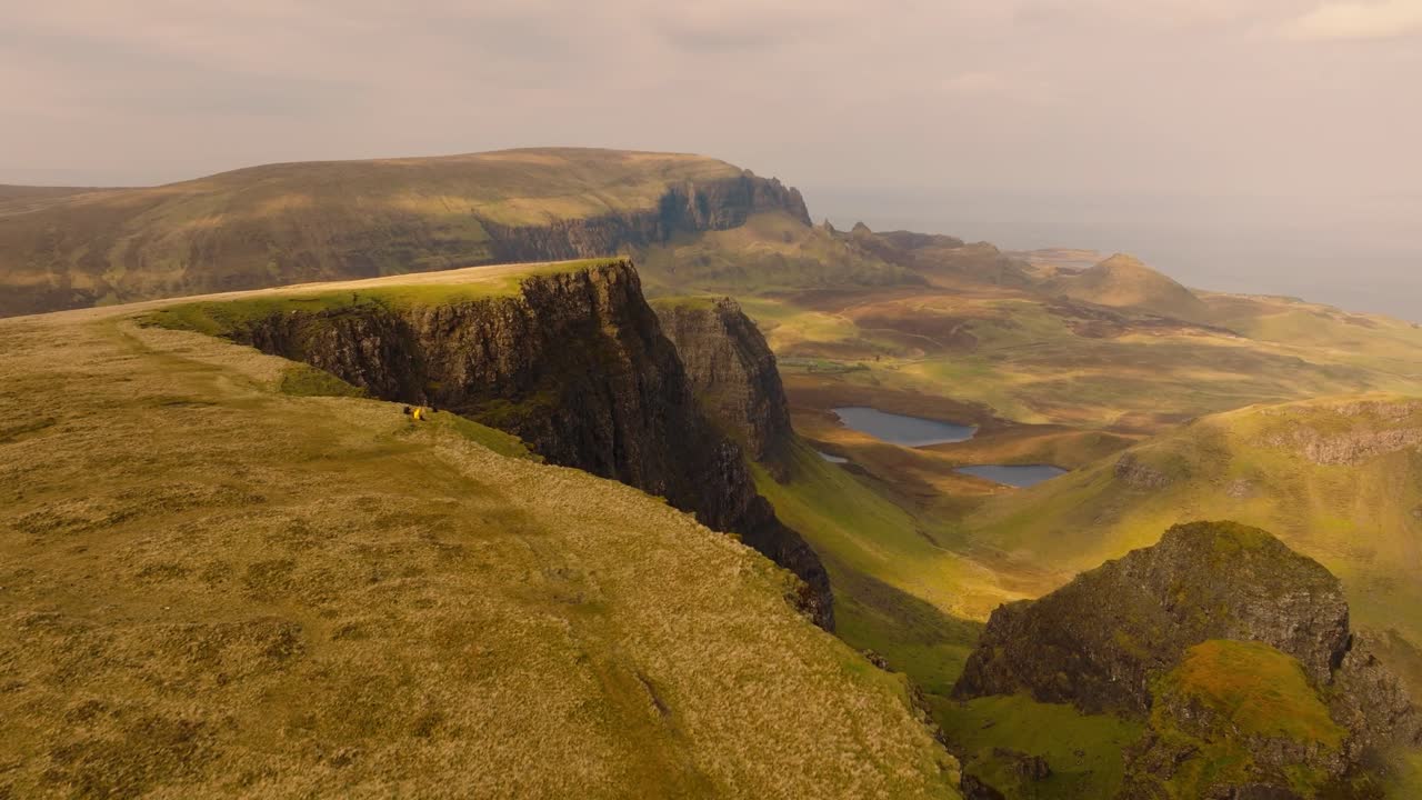 Aerial drone footage of the dramatic mountain landscapes on the Isle of Skye, Scotland. Sweeping panoramic views of majestic peaks, green valleys, and wild nature