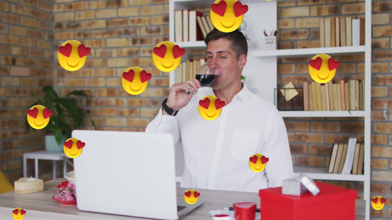 animación de emojis con corazones rojos volando sobre un hombre caucásico bebiendo vino tinto en una videollamada portátil