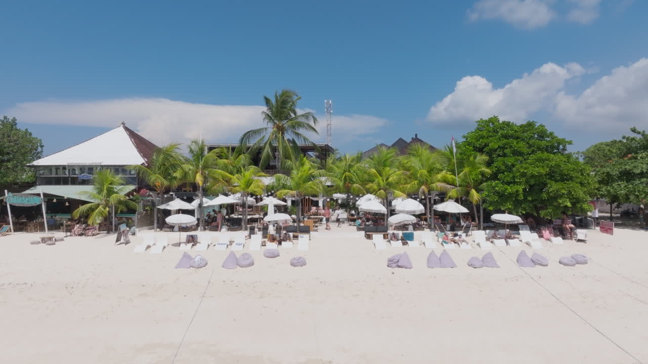 Drone clip showing tropical island resort with palm trees and white sand beach