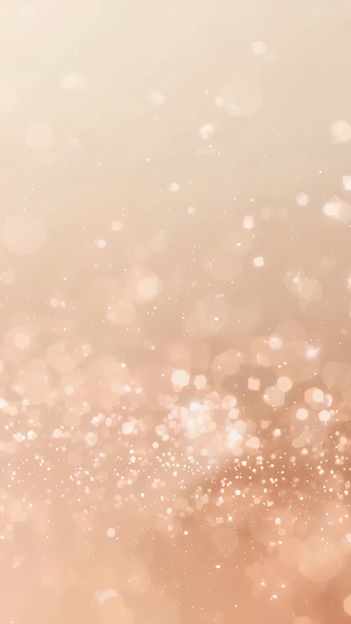 Video verticale: campo bokeh iniziale che si sposta verso l'alto scintillando, per poi svanire su un beige caldo con macchioline