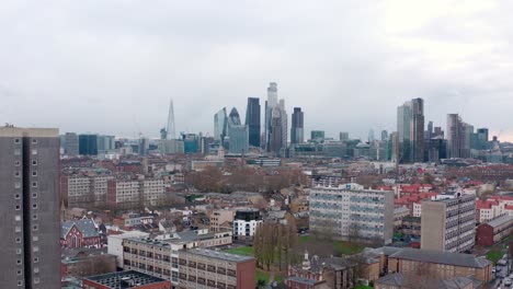 aerial dolly back shot over residential area to central london skyscrapers