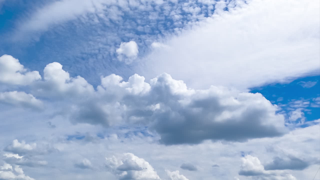 Beautiful cloudscape transformation in the sky. Cumulus and spindrift types of clouds moving on sunny daytime. Timelapse.