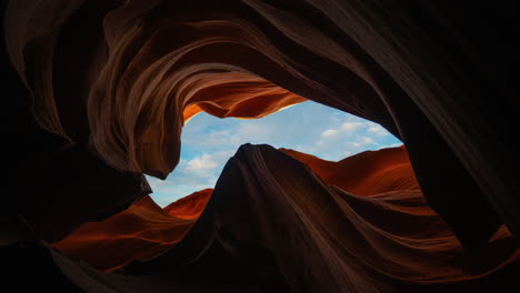cinemagraph time lapse of clouds in blue sky seen through lower antelope canyon sandstone rock walls, arizona.
