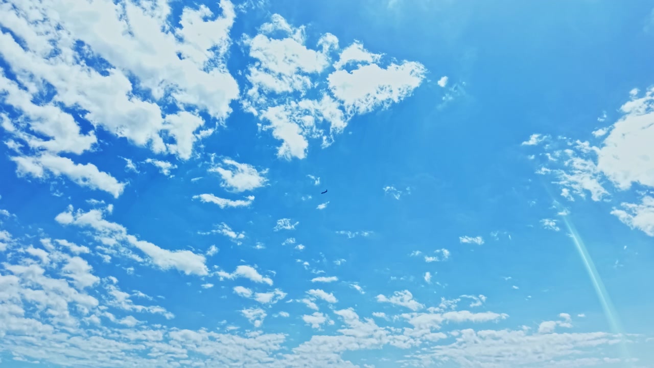鮮やかな晴天の空。澄み切った青空と雄大な雲が広がるエネルギッシュな情景。プロモーションコンテンツに最適な、光り輝く空と移り変わる雲の様子を映画のように表現しています。