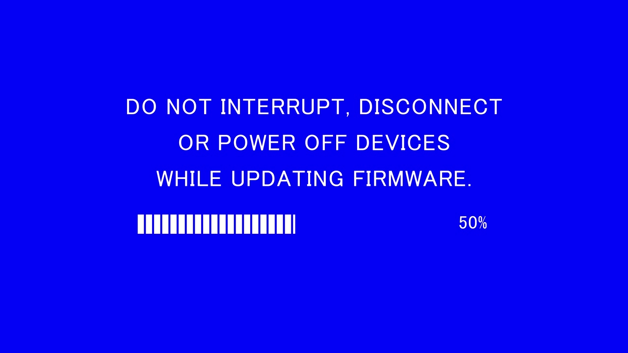 Schermo di una TV retrò che mostra il messaggio "non interrompere, disconnettere o spegnere i dispositivi durante l'aggiornamento del firmware" su sfondo blu.