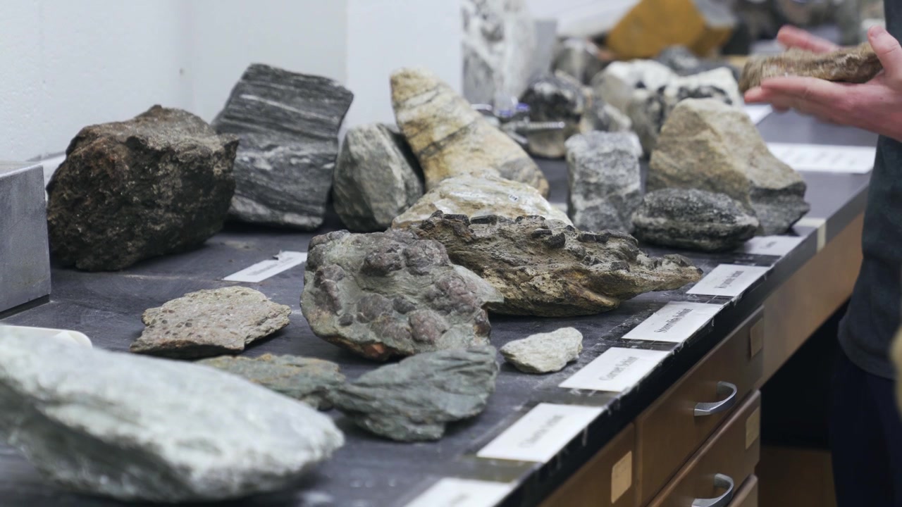 Étudiants universitaires étudiant de grosses roches dans un cours de géologie
