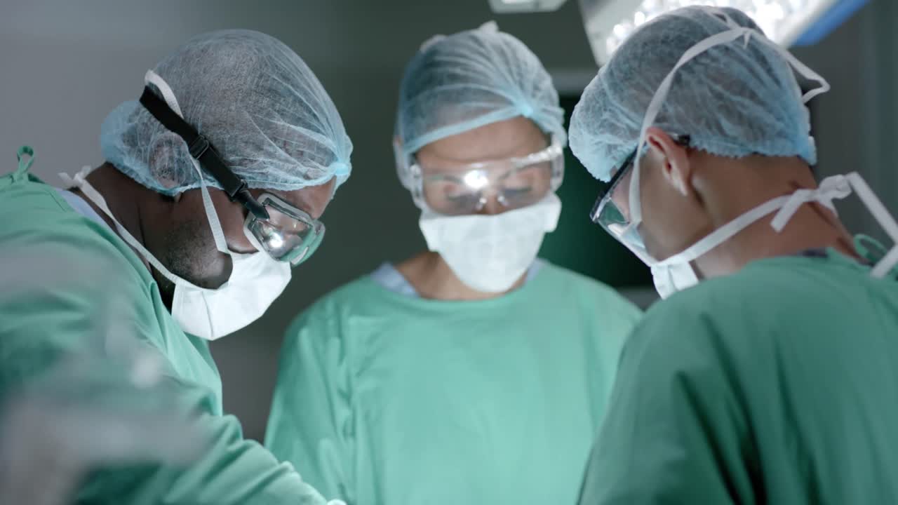Chirurghi diversi con mascherine chirurgiche durante un intervento in sala operatoria al rallentatore