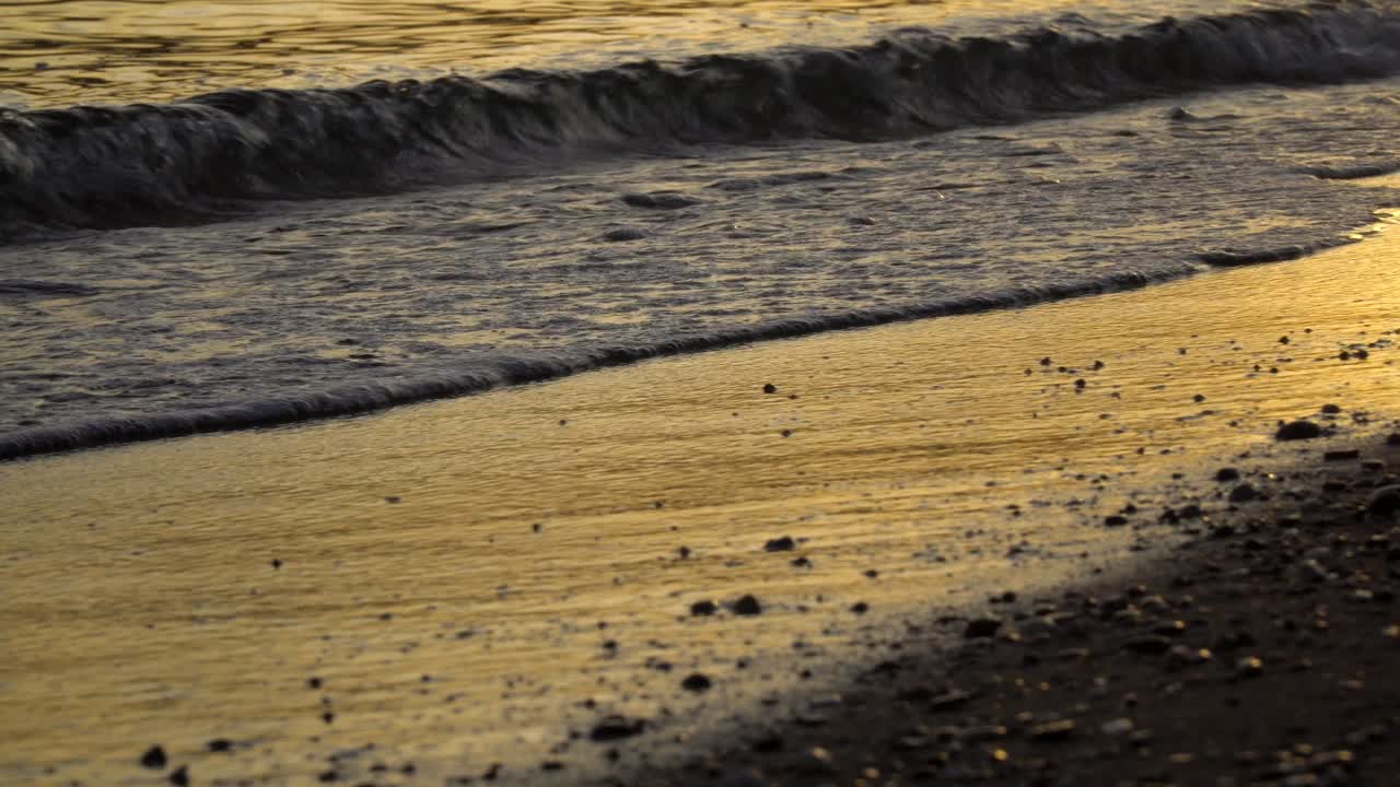 Close up on ocean waves from beach during sunset