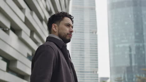 Middle-age-handsome-man-stands-in-downtown-business-district-alone,-thinking,-contemplating-about-life