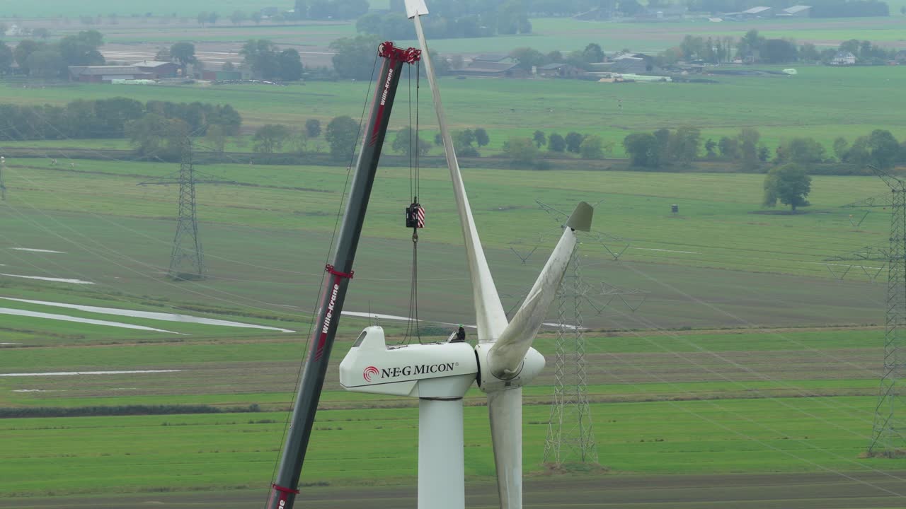 Vista dall'alto di un tecnico eolico che effettua manutenzione a una turbina in quota