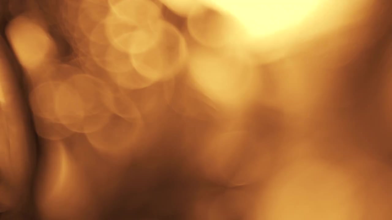 Abstrakt gylden lys-bokeh-overgang på sort baggrund