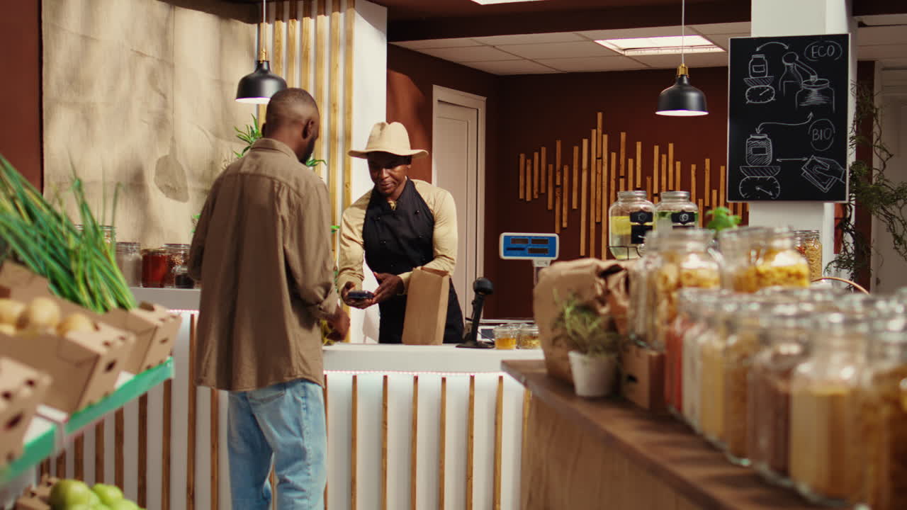 cliente vegano usando tarjeta en pos para pagar por alternativas de alimentos naturales