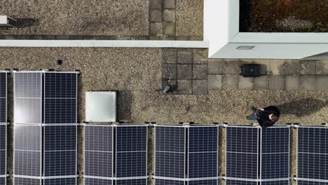 Top-down-shot-of-drone-starting-from-a-roof-between-solar-panels