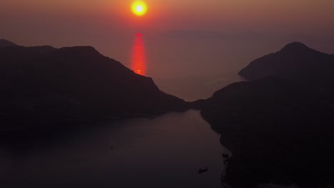 Golden-aerial-view:-Orange-ocean-sunset-behind-mountainous-islands