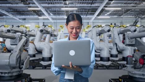 mujer trabajando con una computadora portátil en una instalación de fabricación moderna