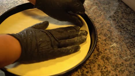 chef preparing fresh pizza dough in a round form