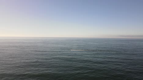 drone shot flying towards fishing boat in big open ocean