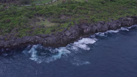 Waves-crashing-at-rocky-cliff-at-Sumba-island-during-sunrise,-aerial