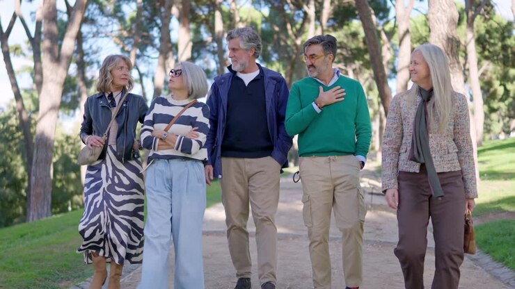 Group of Mature Friends Walking and Talking in a Park