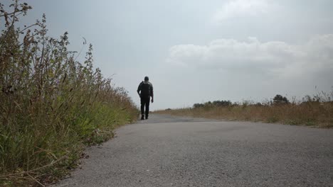 bald male wearing backpack walking along prince's walk in margate