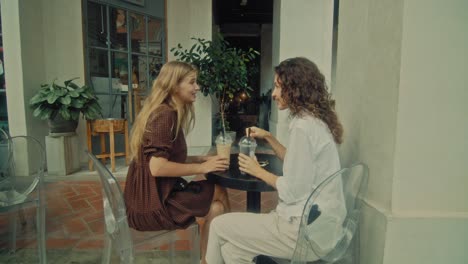 zwei weibliche freunde genießen im freien kaffee