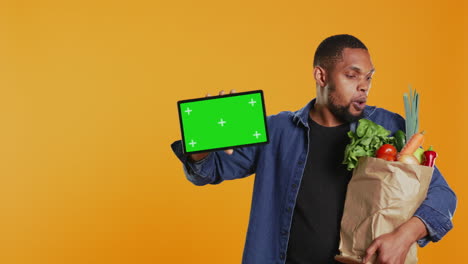 African-american-guy-showing-a-tablet-with-greenscreen-layout