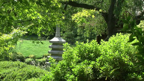 stone pagoda seen amidst trees and greenery in a japanese garden