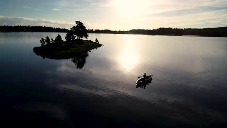 beautiful colorado sunrise on a lake with a silhouette of a canoe against the rising sun