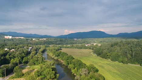 Aerial-pan-shot-of-the-French-Broad-river-and-Carrier-Park-in-Asheville,-NC