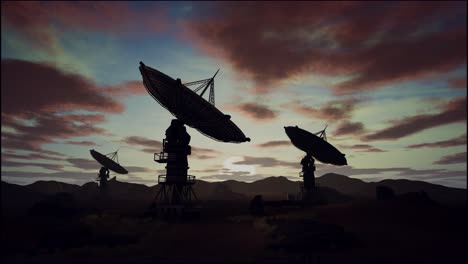 satellite dishes on field against cloudy sky during sunset