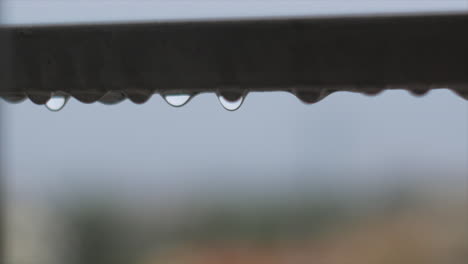 detailed rain droplet bouncing on steel balcony guard, heavy rain