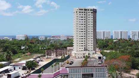 drone scene from above showing building under construction in tourist zone in juan dolio, tourist hotels background