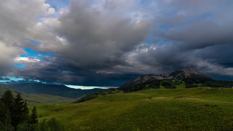 timelapse, rainbow and low clouds moving above landscape of crested butte, colorado usa