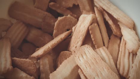 la mano alcanza galletas navideñas recién horneadas de un tazón