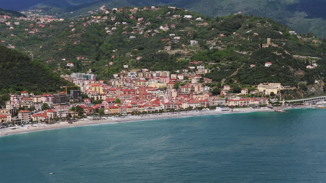 Picturesque coastal town of Noli, Italy, colorful buildings, sandy beach and turquoise Ligurian Sea. Aerial drone lateral view, copy space